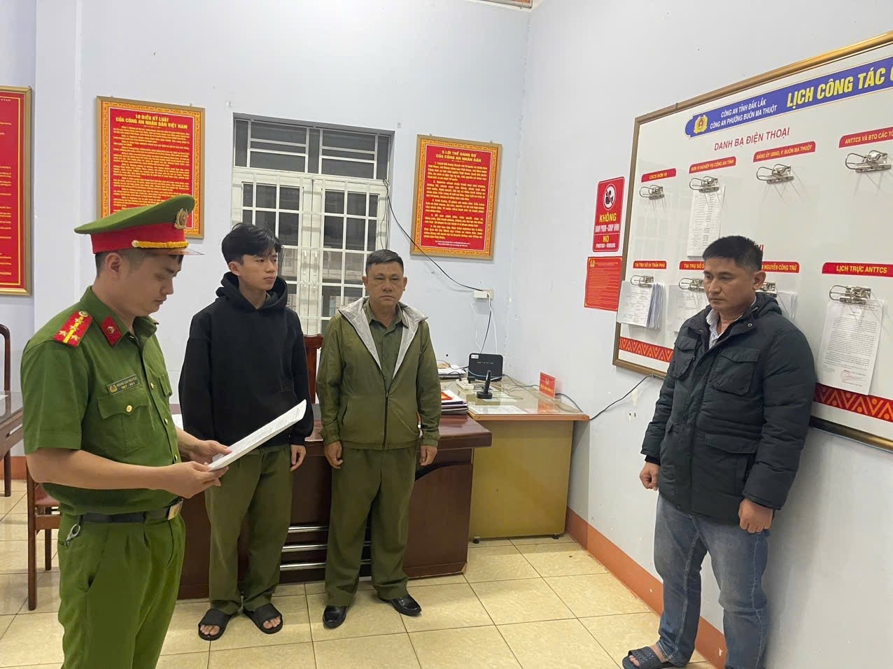 Công an đọc lệnh khởi tố đối với Nguyễn Huy Vũ (bìa phải).